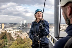 Burgemeester Schouten overwint hoogtevrees met training voor abseilen vanaf Euromast